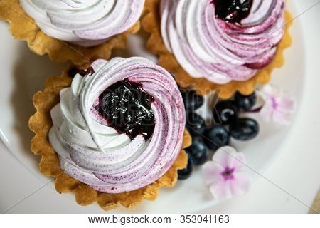 Sweet Tartlet With Meringue And Huckleberry Jam And Phlox Flowers On White Background Closeup