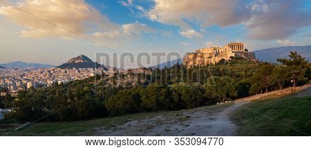 Panorama of famous greek tourist landmark - the iconic Parthenon Temple at the Acropolis of Athens as seen from Philopappos Hill on sunset. Athens, Greece