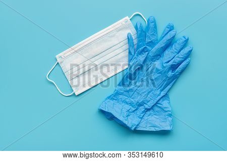 Pair Of Latex Medical Gloves And Surgical Ear-loop Mask On Blue Background. Protection Concept