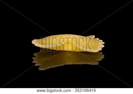 One Whole Yellow Pasta Farfalle Isolated On Black Glass