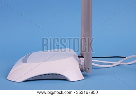 White Wi-fi Router On A Blue Background. Free Space For An Inscription.