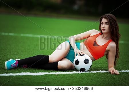 girl-football player in top and shorts on the football field