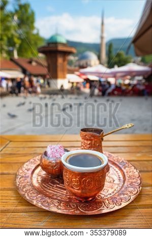 Traditional black bosnian coffee at Bascarsija square in old town of Sarajevo. Famous Sebilj fountain at Bascarsija square in old town of Sarajevo at background, BiH