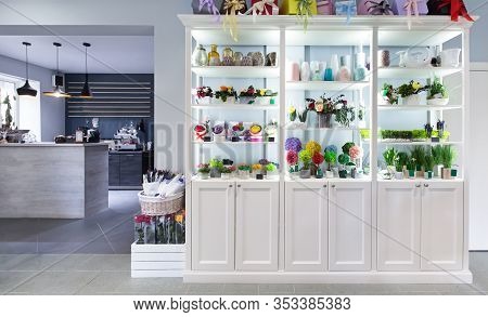 Shelves With Multicolored Flowers In The Room Caffe , Bar On Background