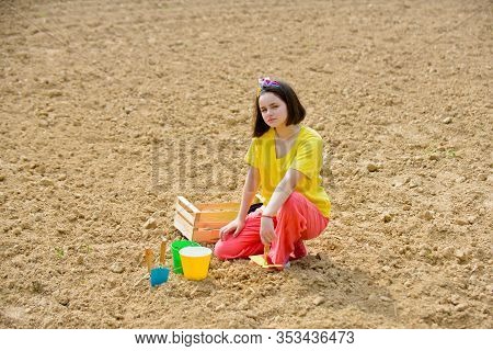 Child Girl Having Fun With Little Shovel And Plant In Pot. Planting Seedlings. Garden Tools