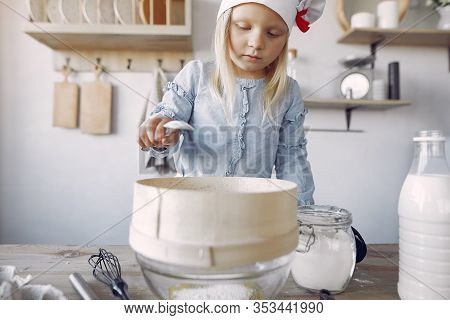 Little Girl In A White Shef Hat Cook The Dough For Cookies
