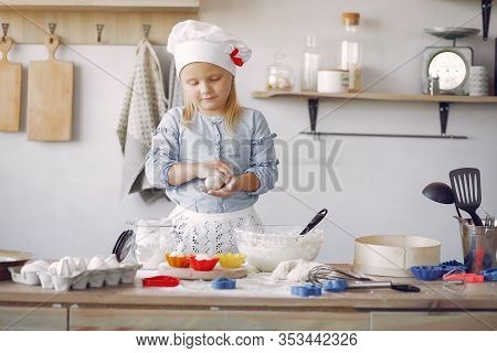 Little Girl In A White Shef Hat Cook The Dough For Cookies