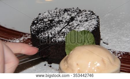 The Child Eats Fondan. Hands Cut Sweet Chocolate Dessert.