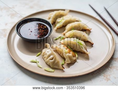 Chinese Traditional Dumplings - Gyoza With Pork And Vegetables On A Round Plate With Soy Sauce In A 