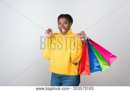 Excited African American Woman With Shopping Bags. Agitated Attractive Young Lady With Raised Hands 