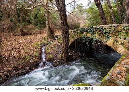 Beautiful Medieval Stoned Bridge Of Milia With River Full With Water Flowing At Troodos Mountains In