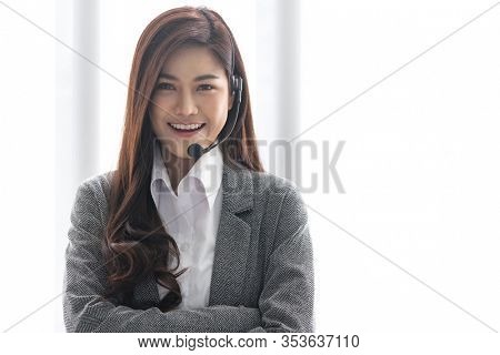 Portrait of Asian young adult friendly and confidence operator call centre with headsets in a call center as customer service and technical support.