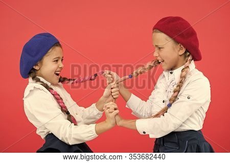 Bullying And Aggression. Naughty Children Pulling Pigtails On Pink Background. Small Girls With Bull