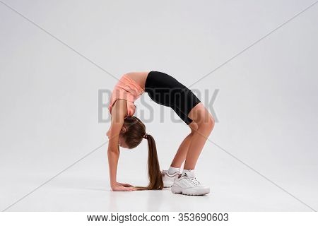 Flexible Cute Little Girl Child Bending Over Backwards While Stretching Her Body Isolated On A White