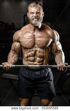 Bodybuilder Strong Man Pumping Up Biceps Muscles