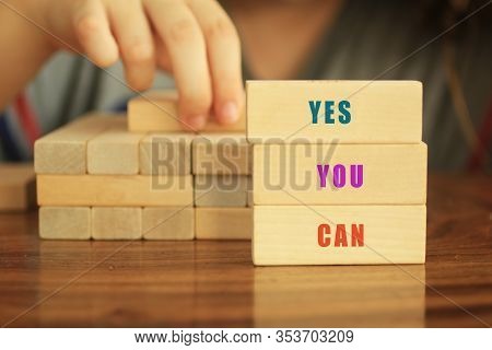 Positive Colorful Single Word On Wooden Block - Yes You Can. With Young Girl Build A Castle From Woo