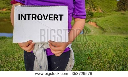 Word Introvert Written On Notepad With Hands Holding It