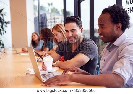 Businessmen And Businesswomen Working In Shared Open Plan Office Workspace