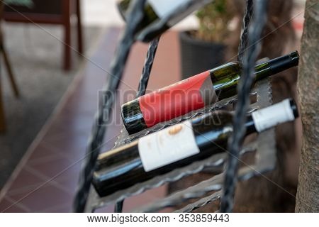 Two Wine Bottles On The Street In A Metal Holder. Selective Focus.