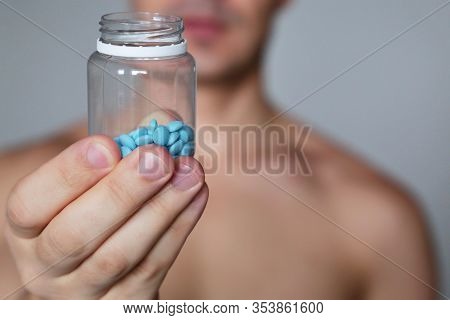 Man With Pills, Bottle With Blue Tablets In Male Hands Close Up. Muscular Guy In With Naked Torso, C