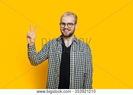 Caucasian Man With Blonde Hair And Short Beard Is Gesturing Greeting With His Fingers While Posing O