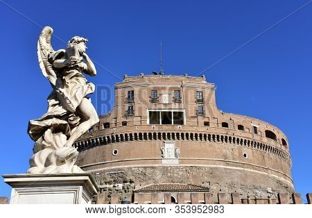 Castel Santangelo And Marble Angel From Ponte Sant Angelo With Blue Sky. Rome, Italy.