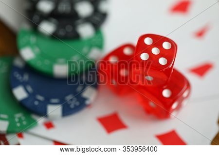 Close-up View Of Red Dice Laying On Table. Macro Shot Of Colourful Casino Chips On Playing Cards. Ga