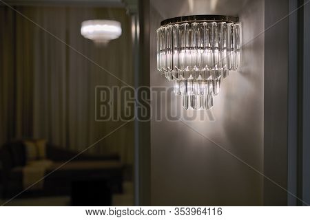 Classic Crystal Sconce Or Lamp On The Wall, With The Light On, At Dusk Or Evening Time. Classic Chro