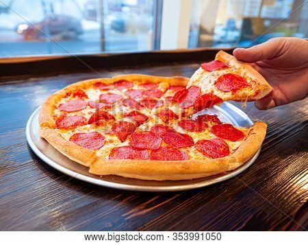 Just Cooked Pizza Pepperoni On A Table In A Cafe In Front Of A Window With A Panorama Of The City. A