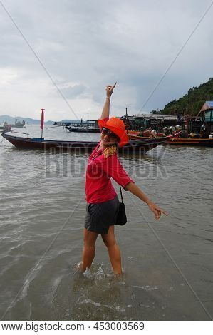 Traveler Thai Women Playing Water In Sea Ocean On Eastern Shore Of The Gulf Of Thailand While Rainin