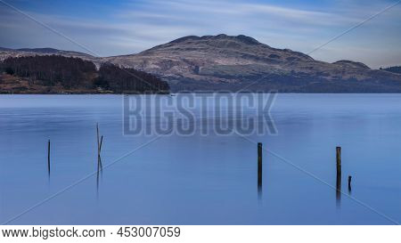 Stunning Landscape Image Of Loch Lomond And Snowcapped Mountain Range In Distance Viewed From Small 