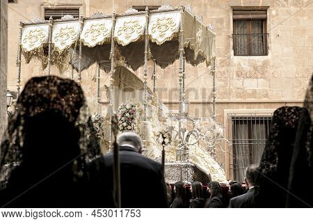 Elche, Spain- April 13, 2022: Virgin Mary On Easter Parade With Bearers And Women Wearing Mantilla D