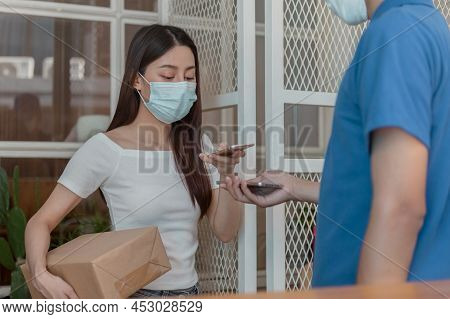 Asian Young Woman, Client Wearing Face Mask, Use Mobile Scan Received  Delivery Of Cardboard Box Fro