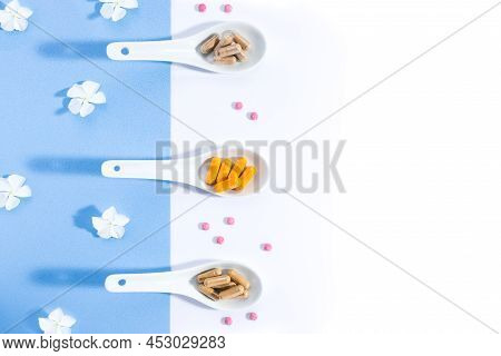 Flat Lay Composition Of Three White Spoons With Nutritional Complexes On White And Blue Background W