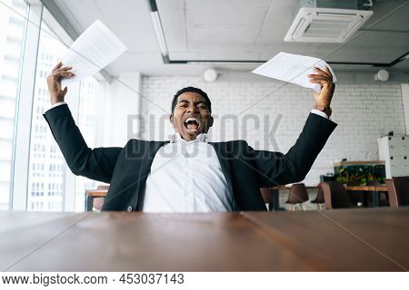 Close-up Low-angle View Of Nervous Excited African American Business Man Throwing Up Paper Account D