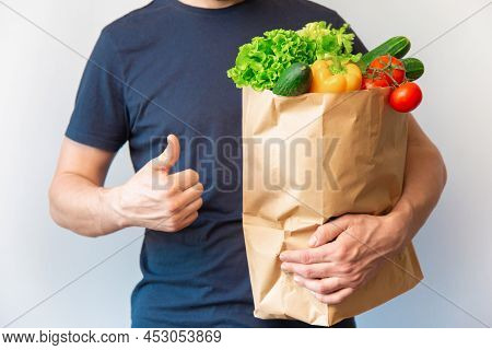 Croped Man With Thumbs Up Holding Paper Bag With Vegetable. Curier Doing Happy Thumbs Up Gesture Wit