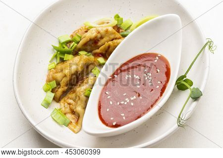 Tomato Sauce In White Porcelain Bowl. Boiled Gedza Dumplings With Greens In Sauce On Plate. Top View