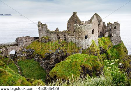 Ruins Of Dunluce Castle, Antrim, Northern Ireland During Sunny Day With Semi Cloudy Sky. Irish Ancie