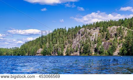 Landscape Of The Forest Lake Yastrebinoye With Ice Age Rocks In The Background.