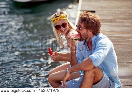 Smiling  young man and woman enjoying together at holiday and eating watermalon