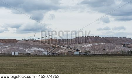 Giant Spreader Or Absetzer Machinery. A Large Dumper On A Landfill With Potash Ore. Extracting And M