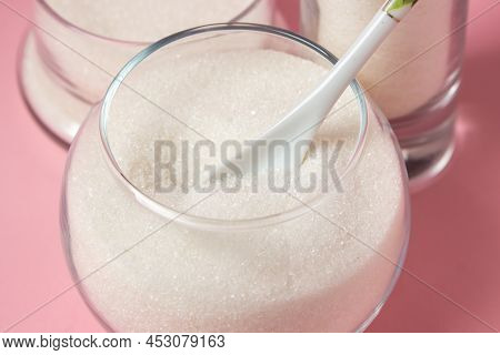 Sugar On A Pink Background. Sugar In Different Glass Vessels. Sugar Reserves