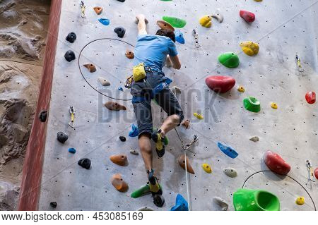 The Climber Trains On The Artificial Rock Wall With Insurance In Bouldering Gym, April 2022, Prague,