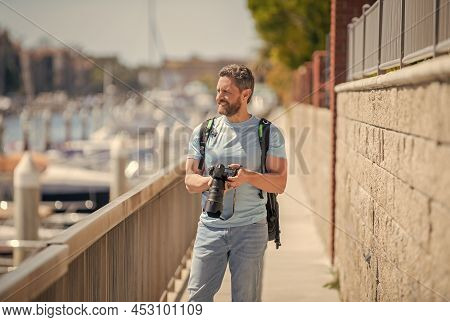 Man Hold Camera Standing On Promenade. Vacation Photography. Travel Photography