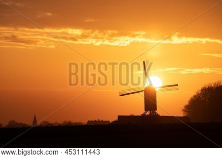 This Beautiful Mountain Mill Is Located In Wannegem-lede Belgium, With The Rise Of The Sun And  Clou