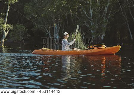 Younger Asian Woman Sailing Sea Kayak In Fresh Water Lagoon