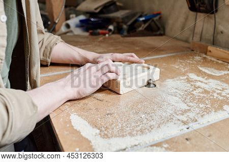 Close-up Of Unrecognizable Joiner Shaping Wooden Object On Benchtop Router Table In Woodworking Work