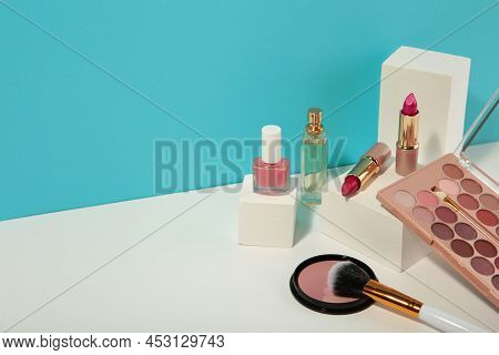 Make Up Products Prsented On White Podium On Blue And White Background. Top View