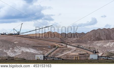 Giant Spreader Or Absetzer Machinery. A Large Dumper On A Landfill With Potash Ore. Extracting And M