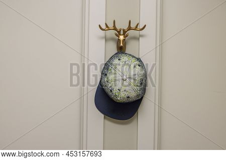 Close Up View Of Keps On Wall Holder In Form Of Guld Horns. Interior Details. Sweden.